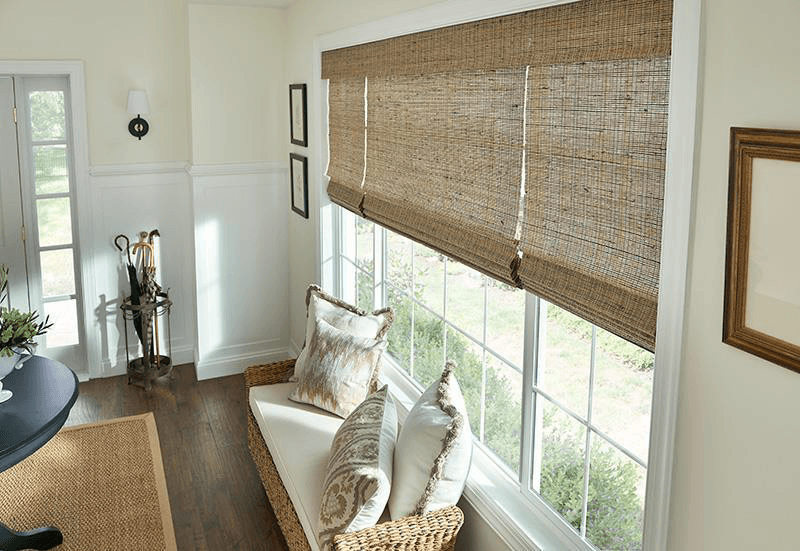 Natural woven wood shades by Graber Blinds - three across one window above a window bench