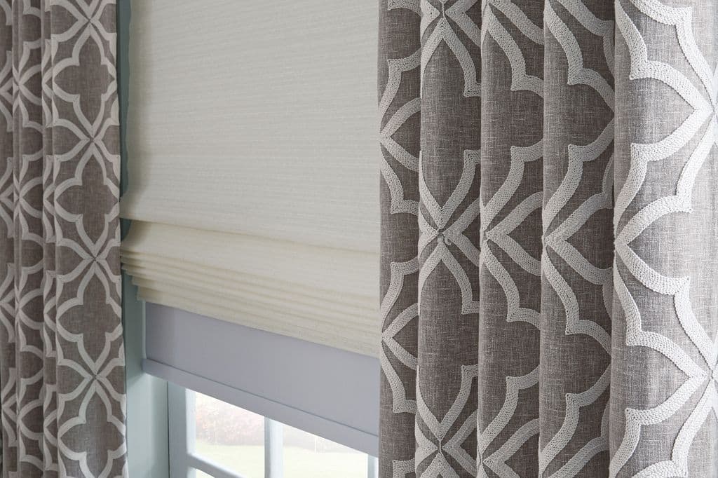 tailored roman shades with patterned layered draperies