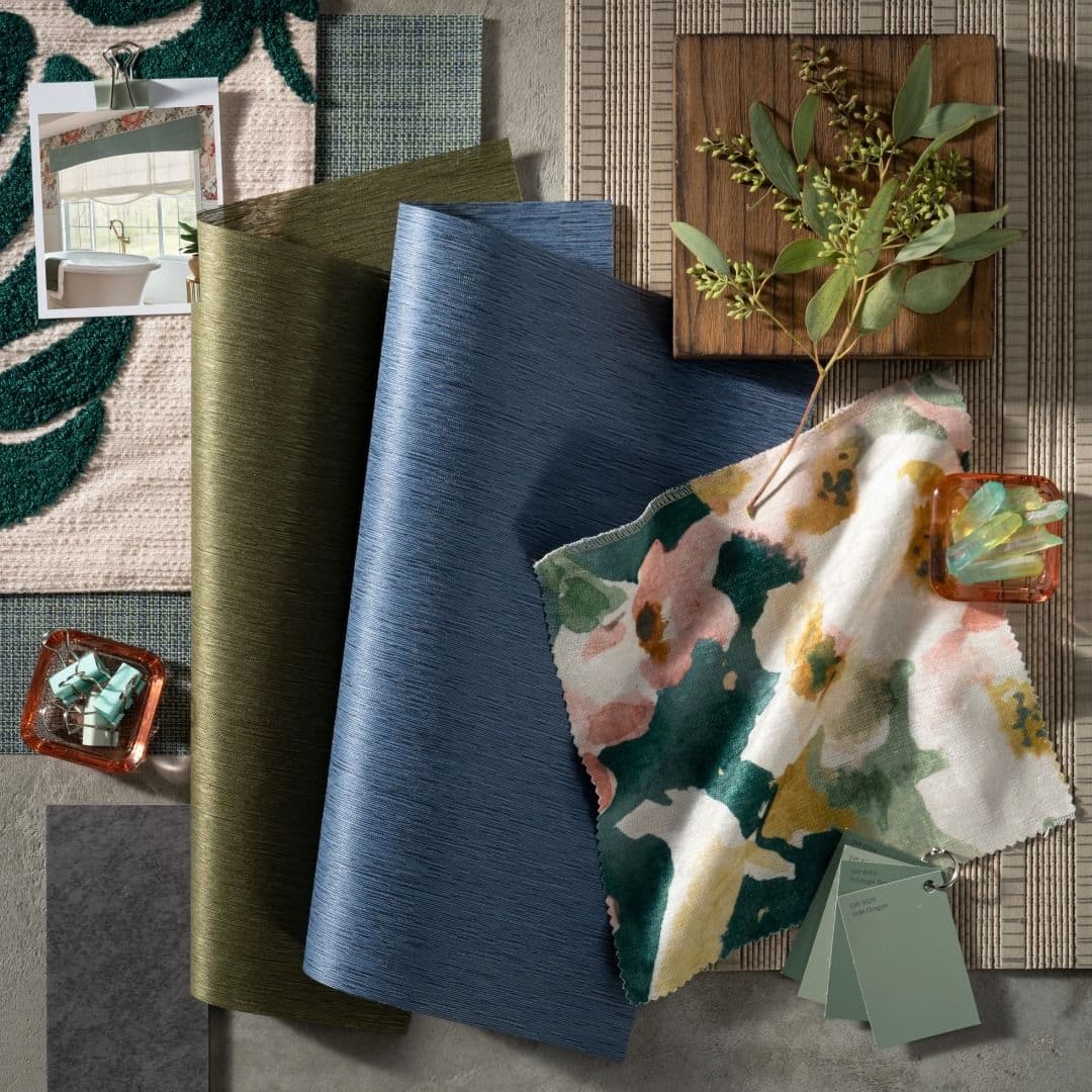 Botanical themed window shade materials with blues and greens and floral accents along with woven wood natural shade material from Graber Blinds