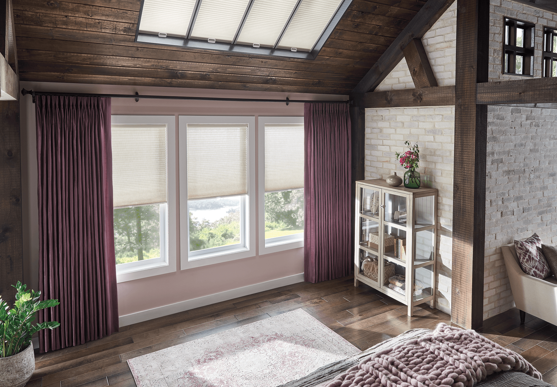 Dark maroon or purple draperies over light cellular shades on the windows and cellular shades on skylights flipped