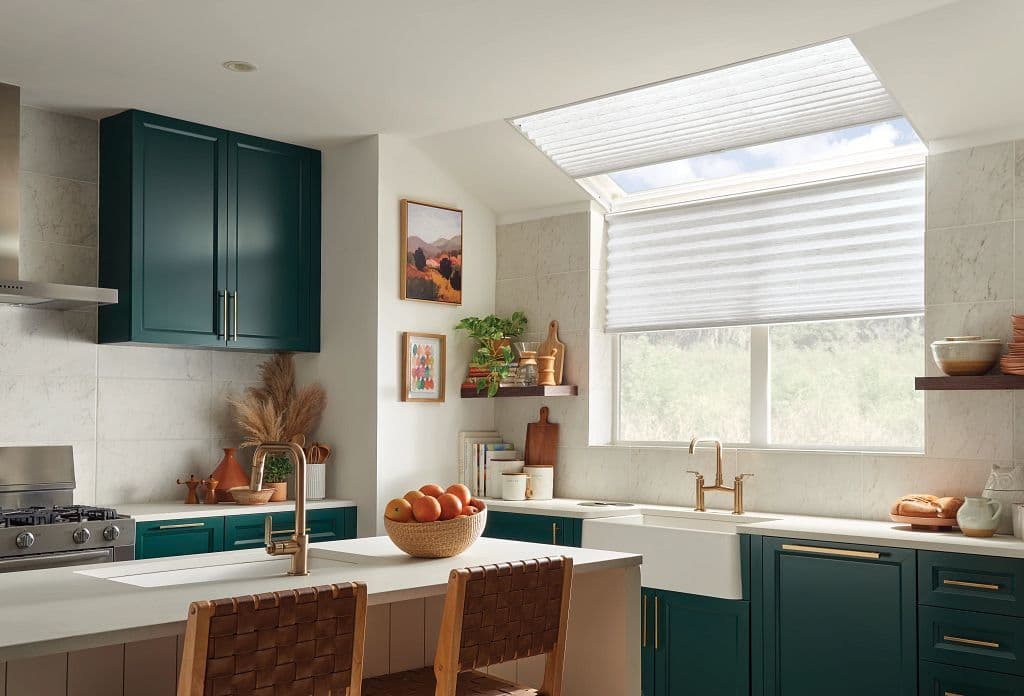 Light and crisp lines of pleated shades above a kitchen sink in the window by Graber Blinds