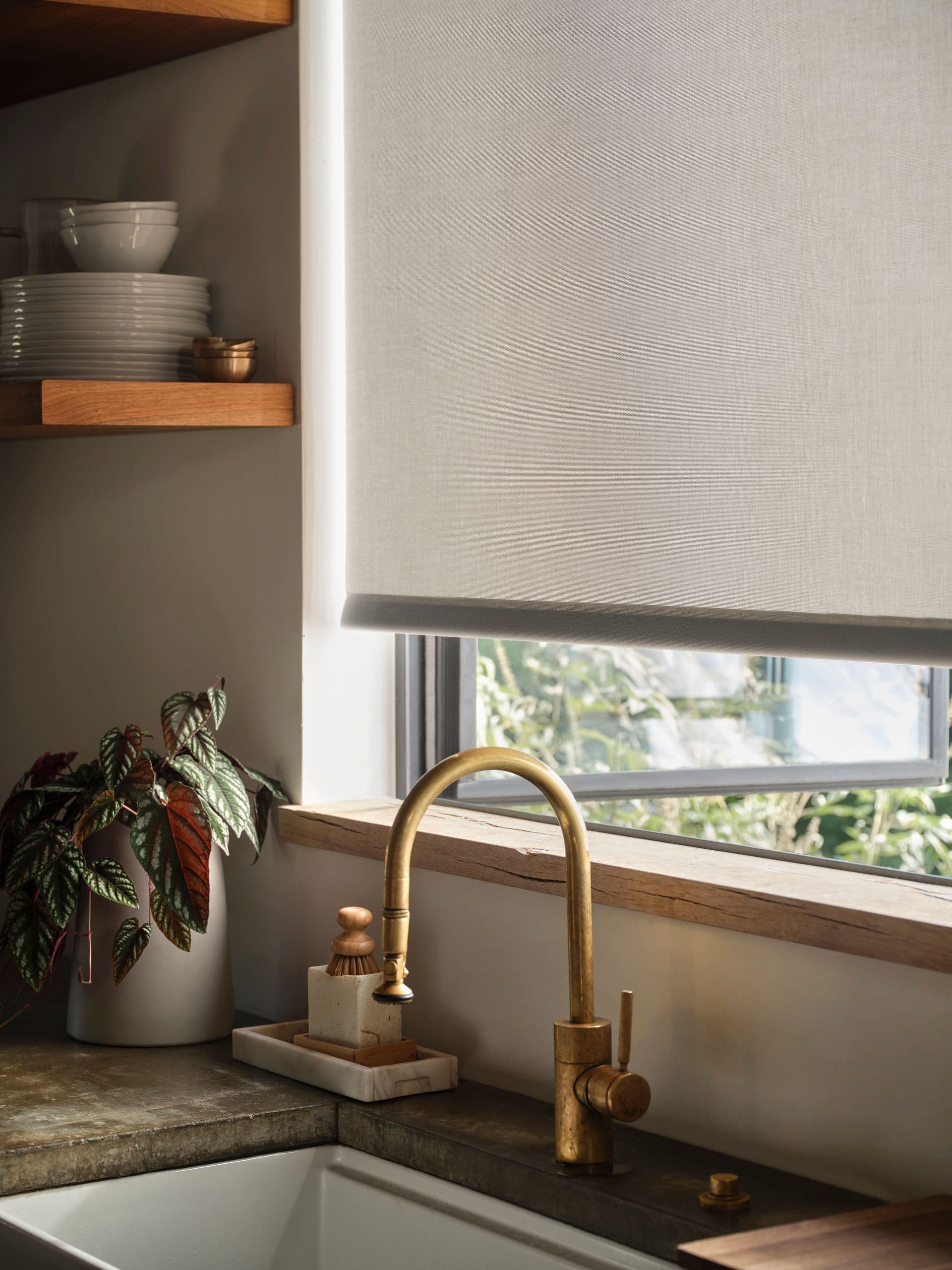A light roller/solar shade above a kitchen sink via Sunbrella